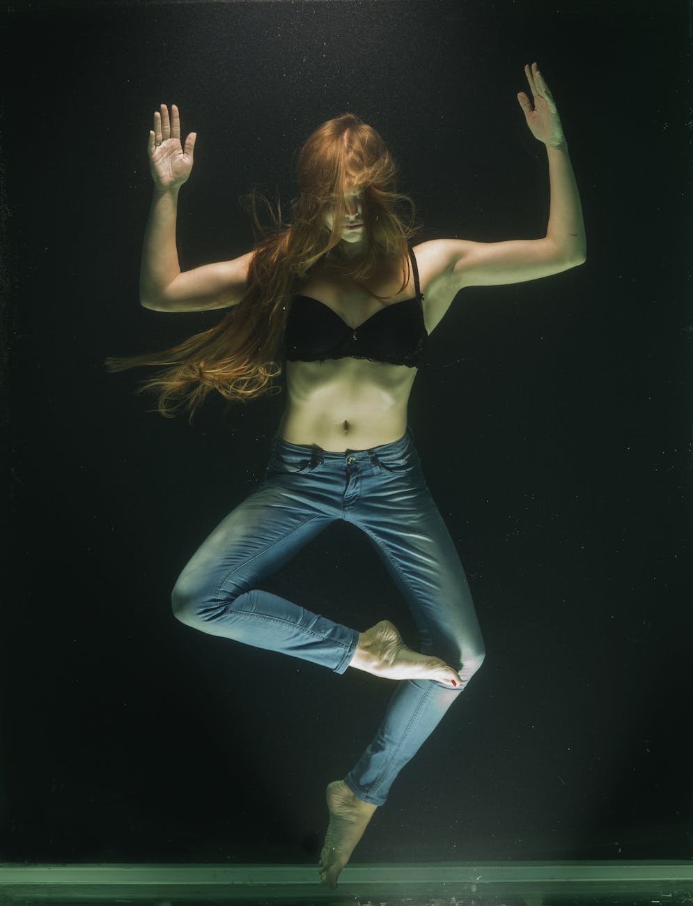 woman wearing black bra and blue denim jeans underwater