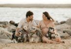 happy couple spending time on beach with cute dogs