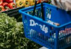 crop person purchasing assorted vegetables in grocery market