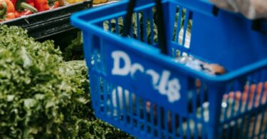 crop person purchasing assorted vegetables in grocery market